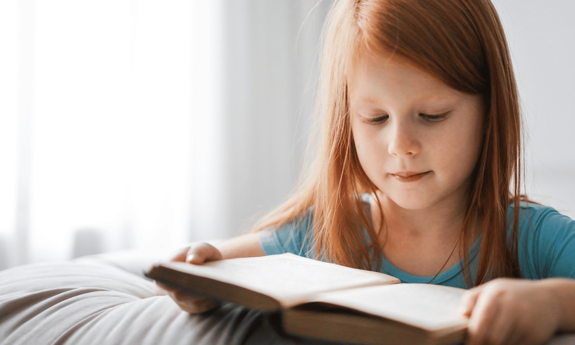 Young girl reading a book — supporting phonics learning with Sounds-Write